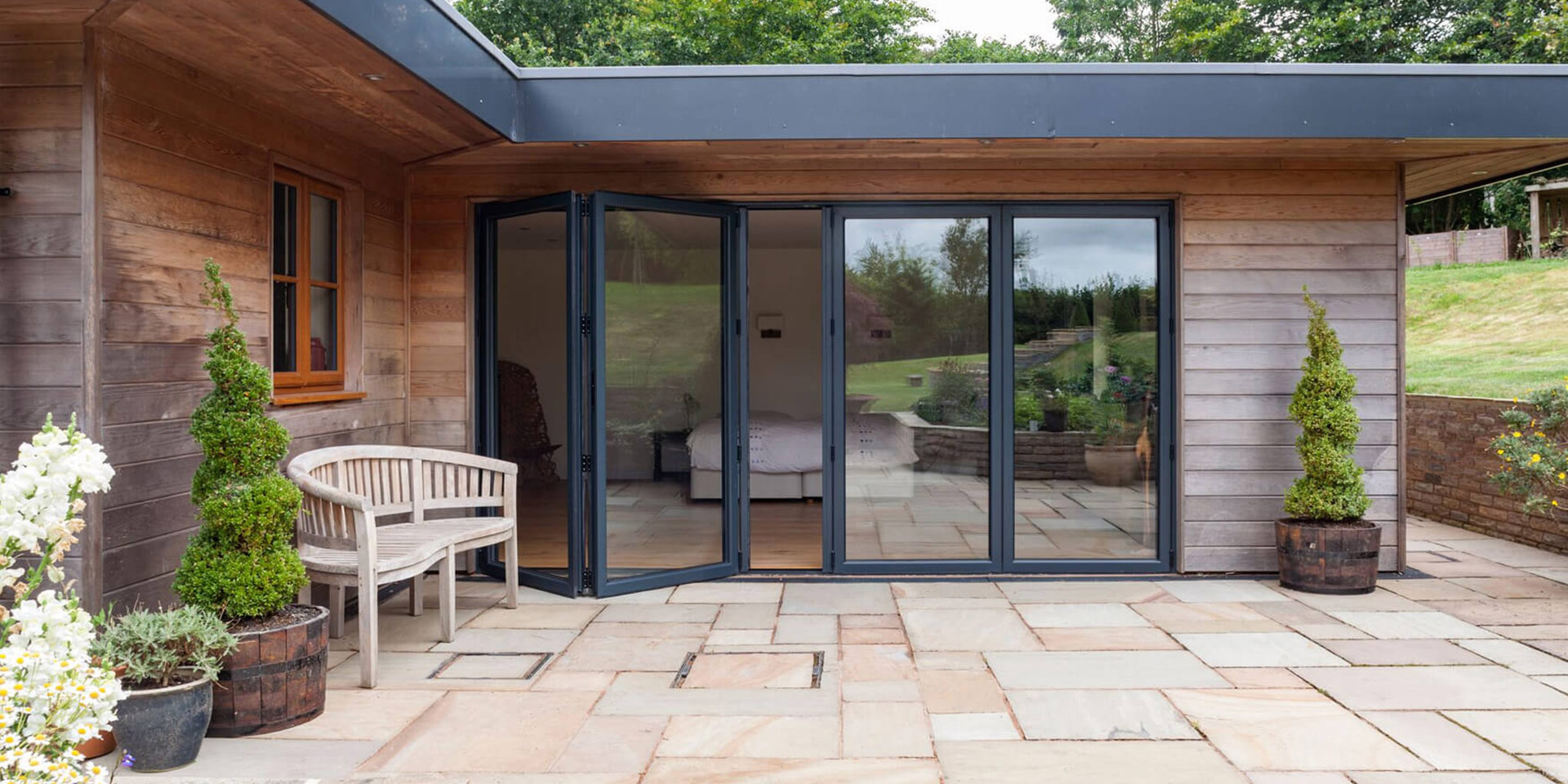 outside view of house extension with anthracite grey aluminium bifold doors in the UK